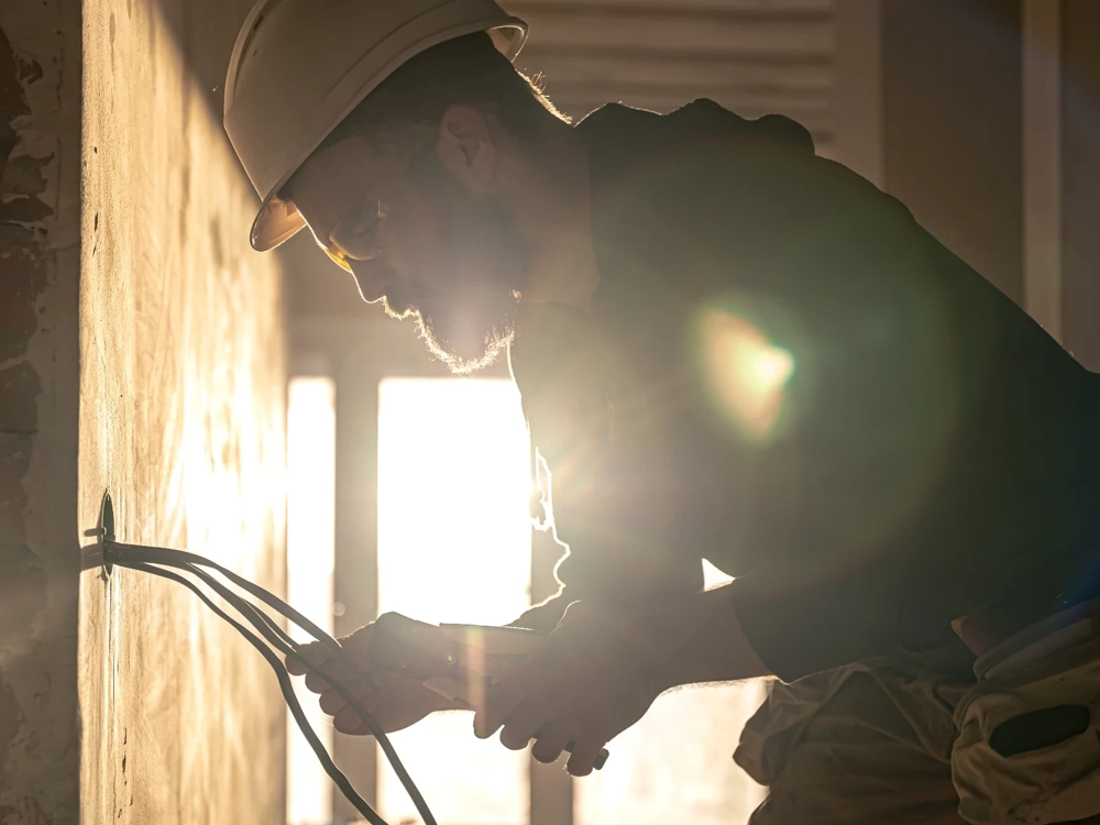 Elektryk montuje przewody w ścianie podczas instalacji elektrycznej