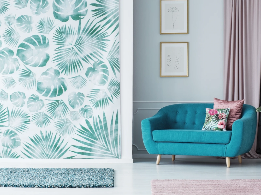 Ściana z tapetą tropikalną, turkusowa sofa i dekoracyjne poduszki w eleganckim salonie. Tapetowanie